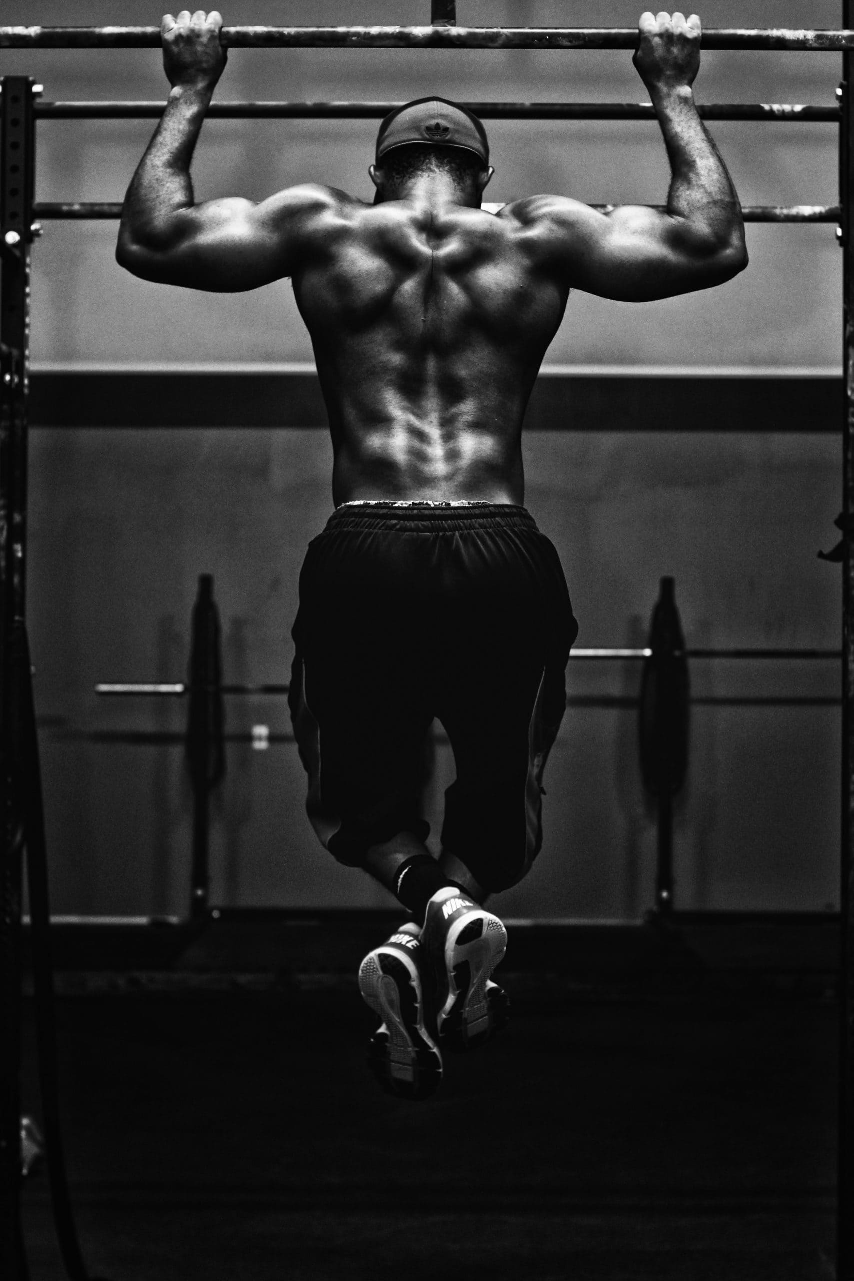 muscular man in gym doing pullups