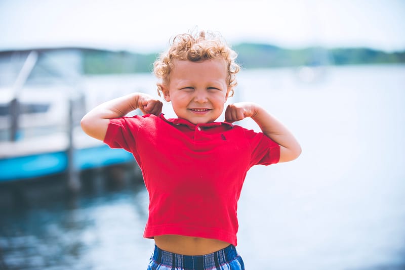 little boy flexing muscles